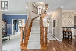 Stairs with crown molding and hardwood / wood-style floors - 
