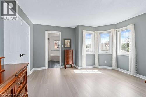 Unfurnished bedroom with light wood-type flooring, multiple windows, and connected bathroom - 119 Parkview Lane, Rockwood, ON - Indoor Photo Showing Other Room