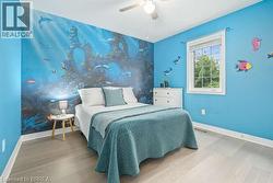 Bedroom with ceiling fan and wood finished floors - 