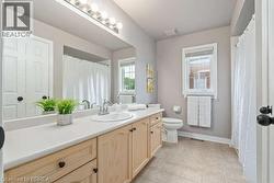 Bathroom with vanity, a shower with shower curtain, and light tile patterned floors - 