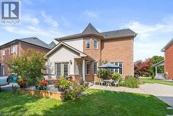 Back of property with a lawn, brick siding, a deck, and a patio - 