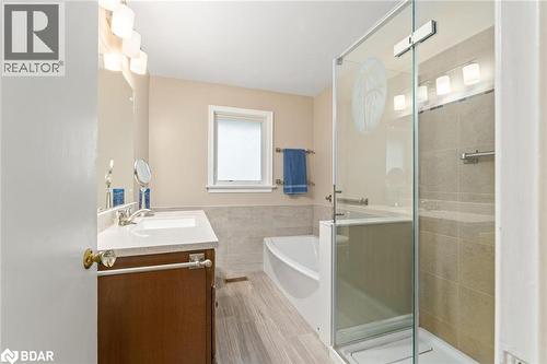 Full bath featuring vanity, a stall shower, a garden tub, and tile walls - 11317 Regional Road 25, Halton Hills, ON - Indoor Photo Showing Bathroom