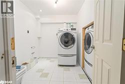 Washroom featuring light tile patterned flooring and independent washer and dryer - 