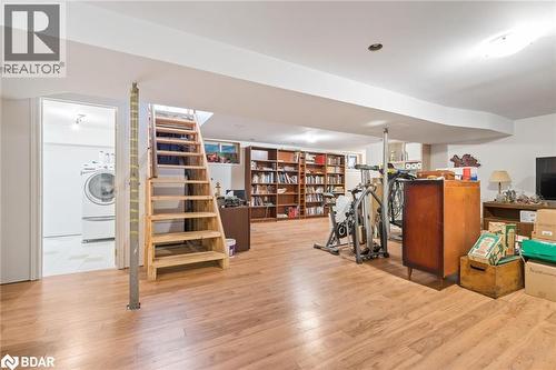 Finished below grade area with light wood-style flooring, stairs, and washer / dryer - 11317 Regional Road 25, Halton Hills, ON - Indoor