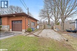 View of home's exterior with asphalt driveway, brick siding, a gate, and a garage - 