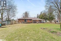 Rear view of house featuring brick siding, a wooden deck, and an outbuilding - 