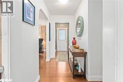 Hallway featuring arched walkways and light wood-style flooring - 