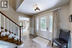 Entryway featuring plenty of natural light, stairway, wainscoting, and a decorative wall - 