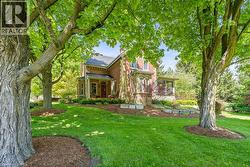 View of front of home featuring a chimney, a front lawn, brick siding, and a porch - 