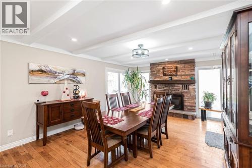 Dining space featuring a stone fireplace, light wood-type flooring, beam ceiling, and recessed lighting - 7087 Rainham Road, Dunnville, ON - Indoor Photo Showing Dining Room With Fireplace