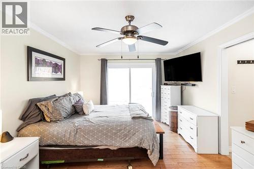 Bedroom featuring crown molding, a ceiling fan, light wood-style flooring, and access to exterior - 7087 Rainham Road, Dunnville, ON - Indoor Photo Showing Bedroom