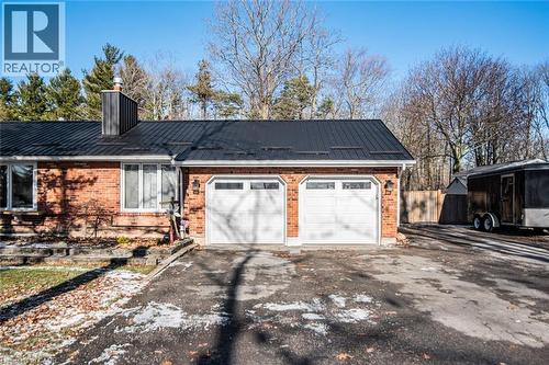 View of side of home with a metal roof, driveway, brick siding, and a chimney - 7087 Rainham Road, Dunnville, ON - Outdoor