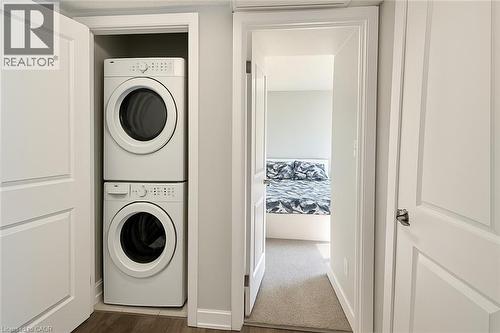 Laundry area featuring stacked washer / drying machine and dark wood finished floors - 185 Windale Crescent Unit# 5A, Kitchener, ON - Indoor Photo Showing Laundry Room