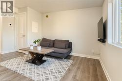 Living area with light wood-style flooring and a textured ceiling - 