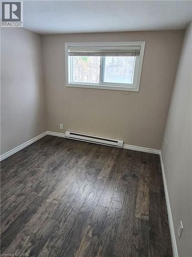 Empty room featuring a baseboard heating unit and dark wood-style floors - 50 Scenic Drive Unit# Lower, Kitchener, ON - Indoor Photo Showing Other Room