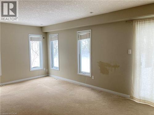 Carpeted empty room with a textured ceiling and healthy amount of natural light - 421 White Birch Avenue, Waterloo, ON - Indoor Photo Showing Other Room