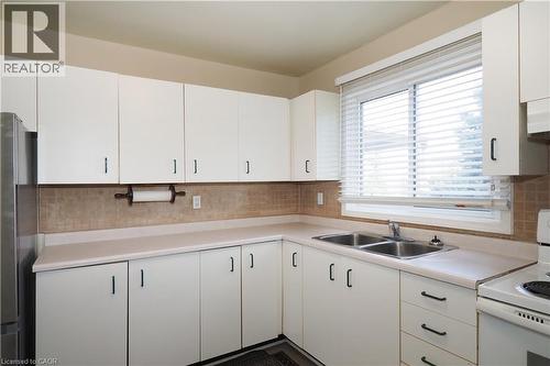 Kitchen featuring white range with electric stovetop, light countertops, and white cabinetry - 255 Northlake Drive Unit# 27, Waterloo, ON - Indoor Photo Showing Kitchen With Double Sink