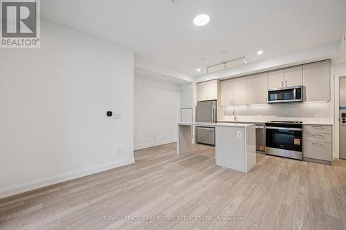Enjoy Wide-Plank Laminate Flooring Throughout - 223 - 3250 Carding Mill Trail, Oakville, ON - Indoor Photo Showing Kitchen With Stainless Steel Kitchen
