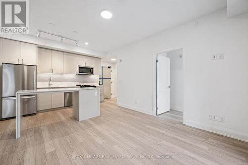 Open Concept Layout Enhanced by Laminate Flooring - 223 - 3250 Carding Mill Trail, Oakville, ON - Indoor Photo Showing Kitchen With Stainless Steel Kitchen