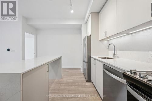 Kitchen Offers Quartz Countertops and Backsplash - 223 - 3250 Carding Mill Trail, Oakville, ON - Indoor Photo Showing Kitchen With Stainless Steel Kitchen With Upgraded Kitchen