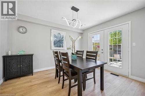 Dining room featuring light wood-style floors, french doors, and a chandelier - 723 Black Cherry Street, Waterloo, ON - Indoor Photo Showing Dining Room