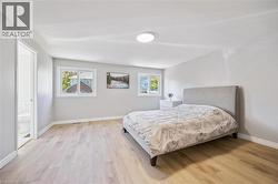 Bedroom featuring light wood-style flooring and ensuite bath - 