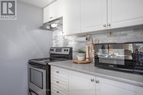 301 - 132 Aspen Springs Drive, Clarington (Bowmanville), ON - Indoor Photo Showing Kitchen With Fireplace