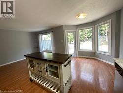 Kitchen with butcher block countertops, light wood-style floors, stainless steel dishwasher, a textured ceiling, and open shelves - 