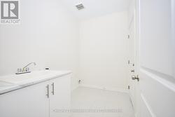 Laundry room w/ access to garage and ceramic sink - 