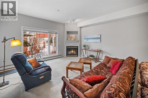 201, 223 Tuscany Springs Boulevard Nw, Calgary, AB - Indoor Photo Showing Living Room With Fireplace