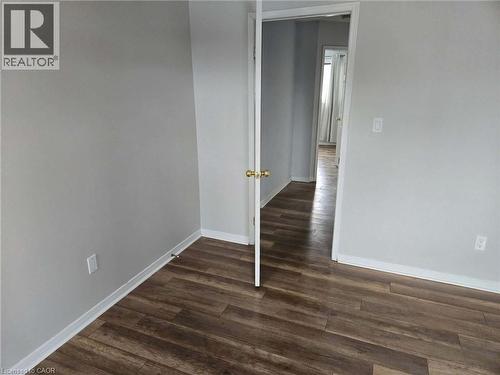Unfurnished room with baseboards and dark wood-style flooring - 185 Sulmona Drive, Hamilton, ON - Indoor Photo Showing Other Room