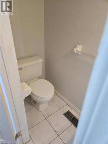 Bathroom with light tile patterned floors and toilet - 185 Sulmona Drive, Hamilton, ON - Indoor Photo Showing Bathroom