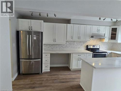 Kitchen with rail lighting, appliances with stainless steel finishes, white cabinetry, and light stone countertops - 185 Sulmona Drive, Hamilton, ON - Indoor Photo Showing Kitchen With Stainless Steel Kitchen With Upgraded Kitchen