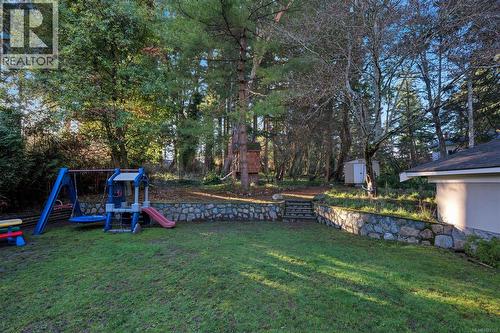 Forested back yard with playhouse - 2229 Arbutus Rd, Saanich, BC - Outdoor With Backyard