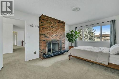 virtually staged. 3rd bed up or den - 811 Tamarack Drive, Kelowna, BC - Indoor Photo Showing Bedroom With Fireplace