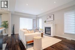 Living area with a glass covered fireplace, dark wood finished floors, and recessed lighting - 