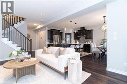 Living area featuring stairway, dark wood-type flooring, and recessed lighting - 