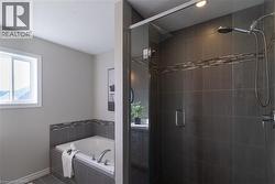 Bathroom with a bath, a shower stall, healthy amount of natural light, a textured ceiling, and tile patterned floors - 