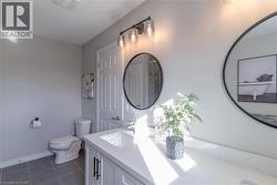 Full bathroom featuring vanity and dark tile patterned floors - 