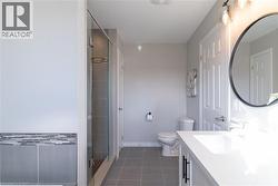 Bathroom featuring vanity, a stall shower, and dark tile patterned flooring - 