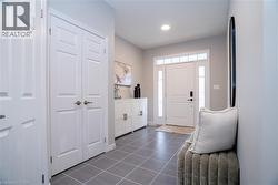 Entrance foyer with dark tile patterned flooring and recessed lighting - 