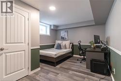 Bedroom featuring wood finished floors and a desk - 