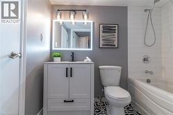 Bathroom with vanity, tub / shower combination, and tile patterned flooring - 