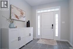 Foyer entrance featuring dark tile patterned flooring and baseboards - 