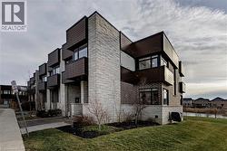 View of home's exterior featuring stone siding, a yard, and a residential view - 