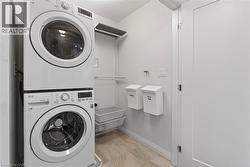 Laundry room with stacked washer / dryer and baseboards - 