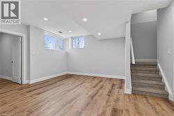 Basement featuring light wood-style flooring, recessed lighting, and stairway - 
