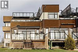 Back of property with stairs, a wooden deck, and brick siding - 