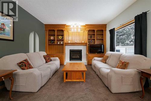 Family with gas fireplace - 247 Mt Selkirk Close Se, Calgary, AB - Indoor Photo Showing Living Room With Fireplace