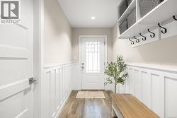 Mudroom with wainscoting, a decorative wall, dark wood-type flooring, and recessed lighting - 